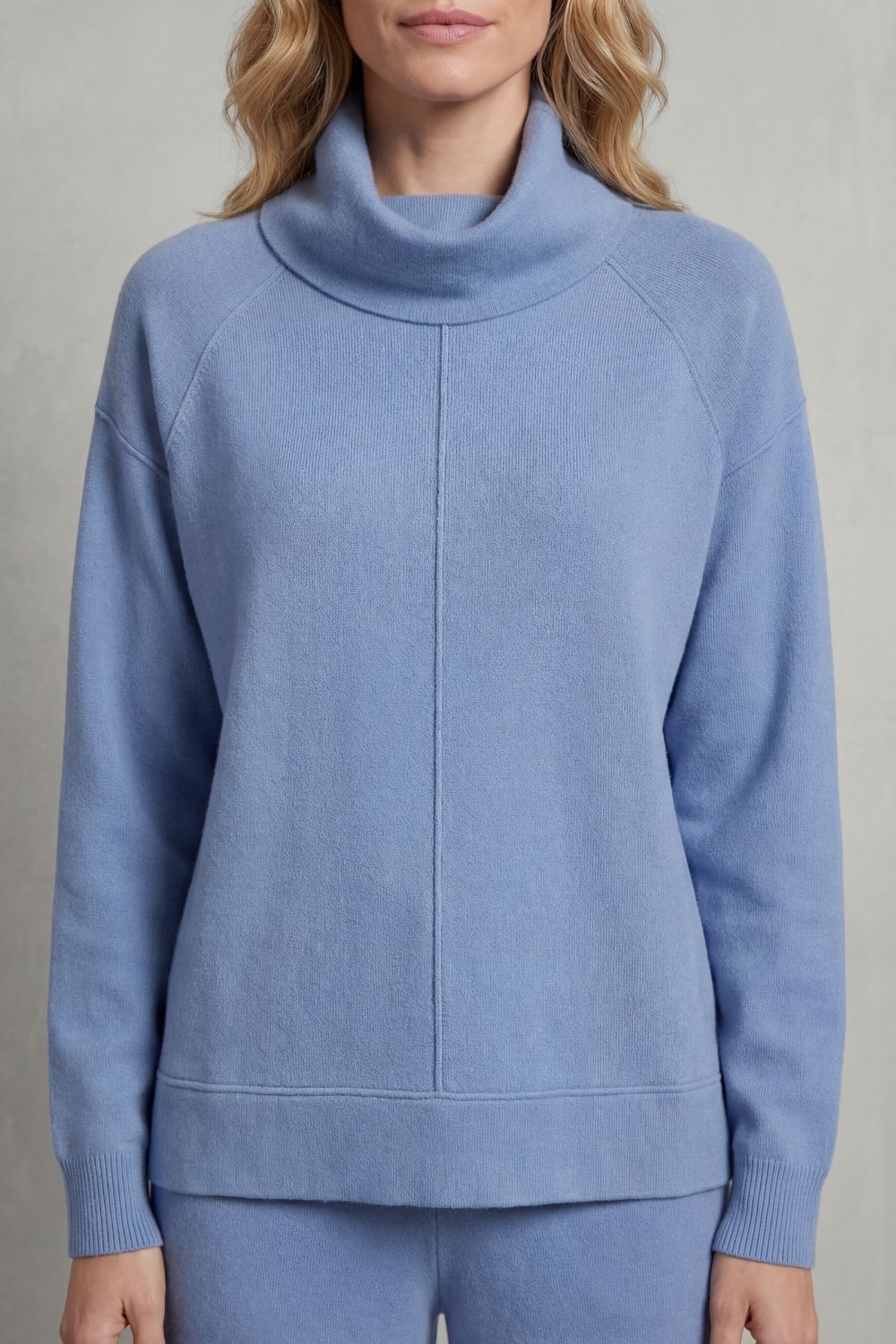 Detail close-up of the draped turtleneck collar on the lounge top