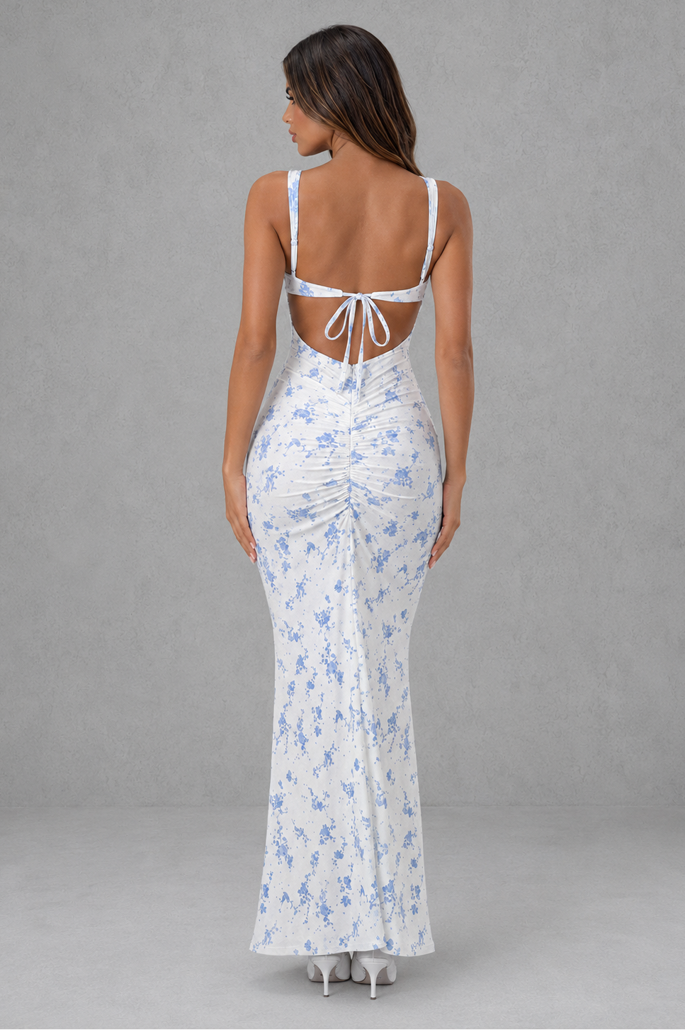 Womenโs blue floral mesh maxi dress with plunge neckline, adjustable straps, and feminine tie-back detail.