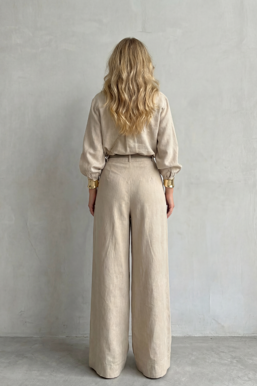 Detail close-up of the belted waist and tailored pleats