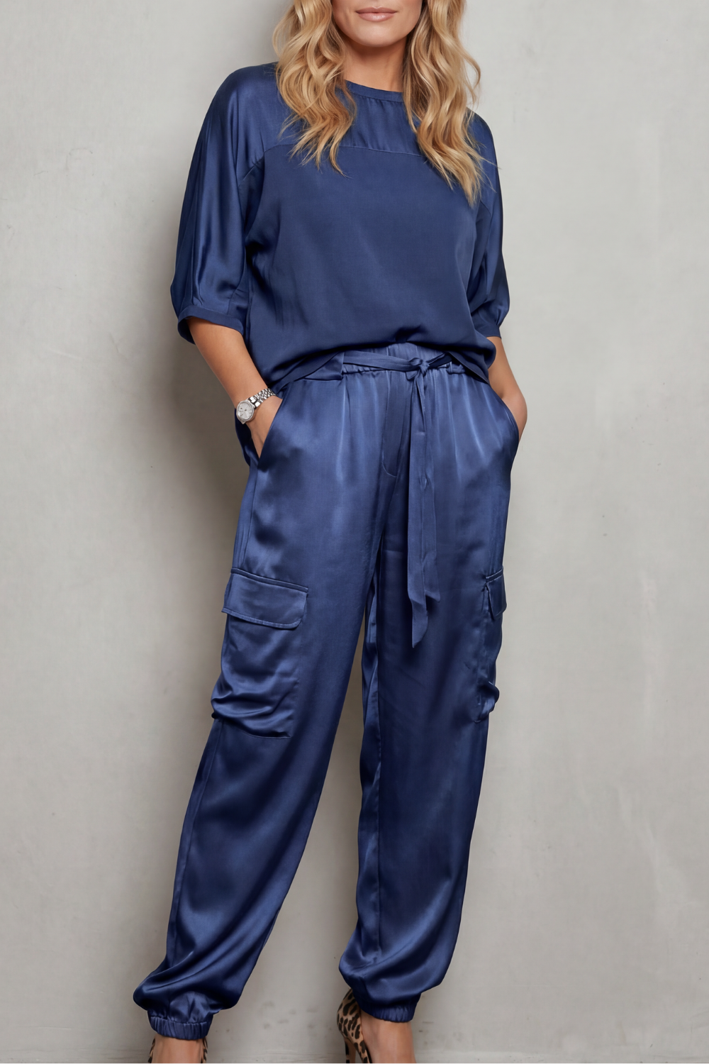 Close-up of the high-shine satin fabric and draped short sleeve