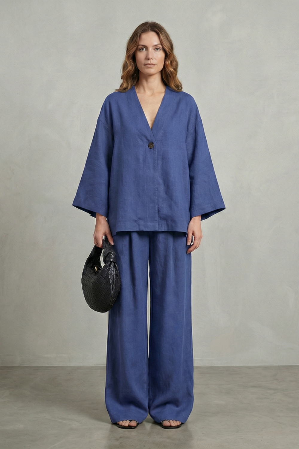 Movement shot of the draped sleeves and flowing wide-leg pants
