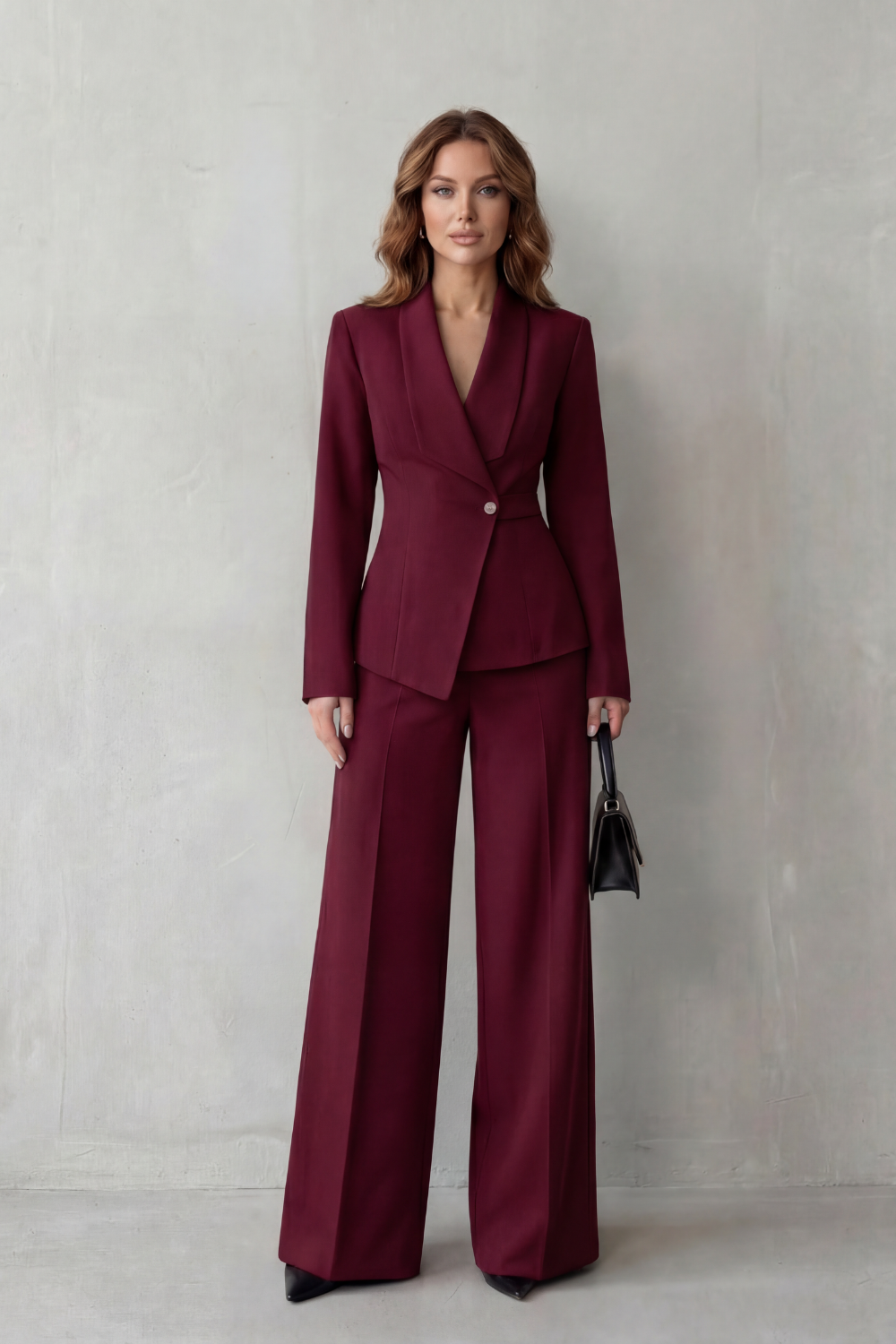 Seated pose showing the fit of the blazer and wide-leg pants suit