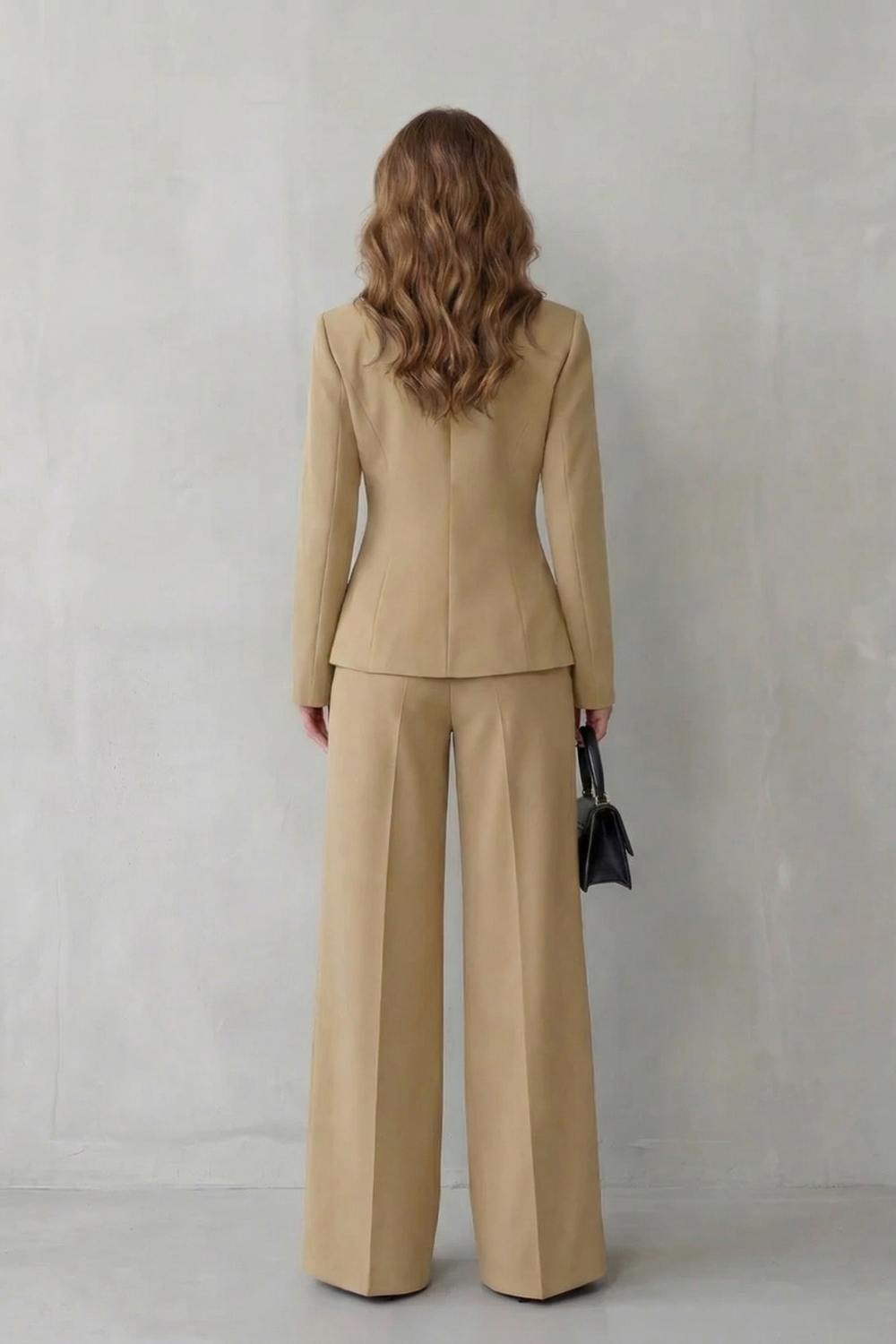 Detail close-up of the asymmetric blazer hem and decorative button