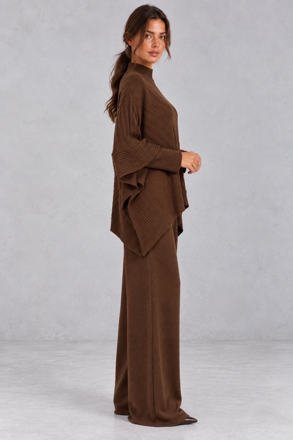 Side view of the draped asymmetric crossover hem on the knit sweater
