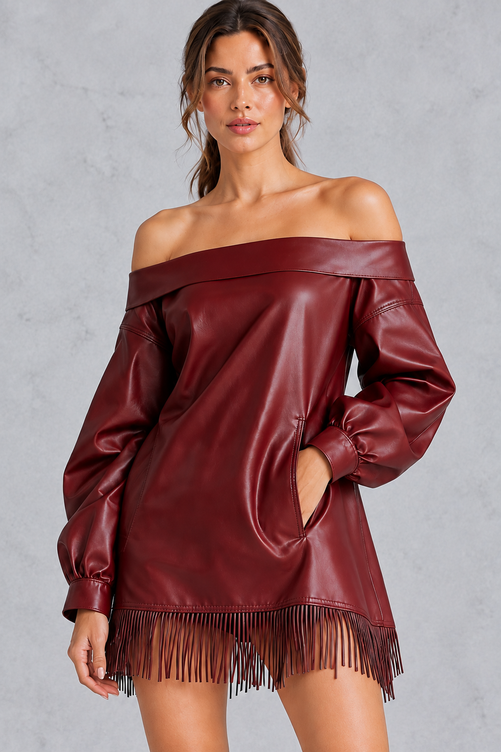 Close-up of the tassel-style fringe hem on a women's faux leather dress