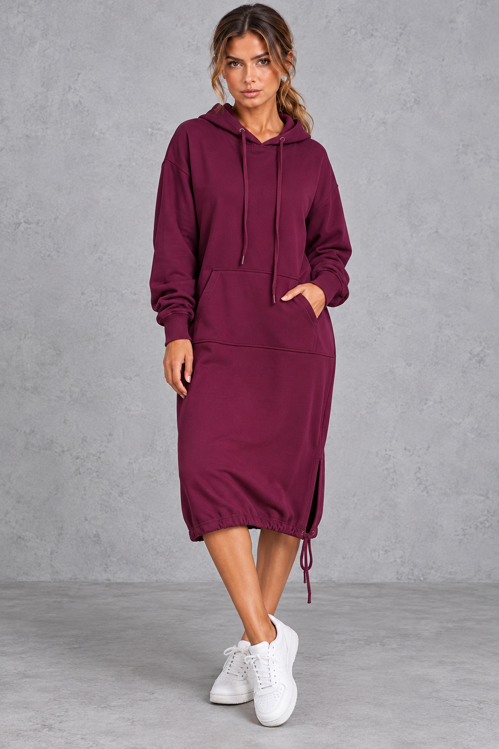 Women's long sleeve hoodie midi dress styled with sneakers for a casual weekend look