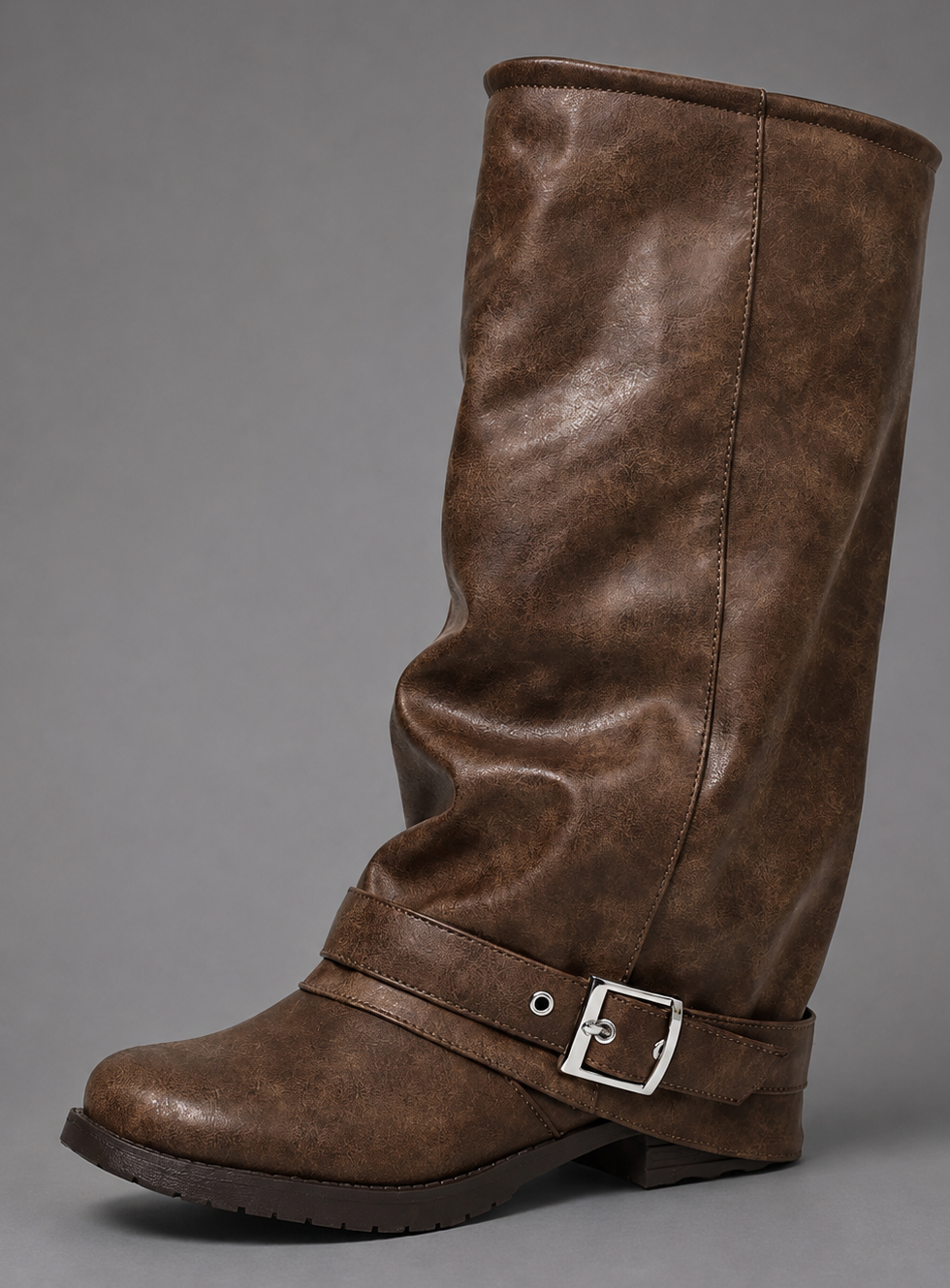 Women’s black slouch knee-high boots with a smooth faux leather upper, round toe, buckle strap detail, low block heel, and chunky lug sole.