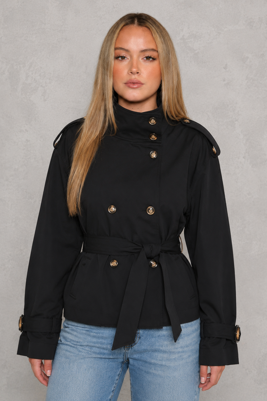 Women’s cropped belted trench coat with a double-breasted button front, structured lapel collar and adjustable tie waist.