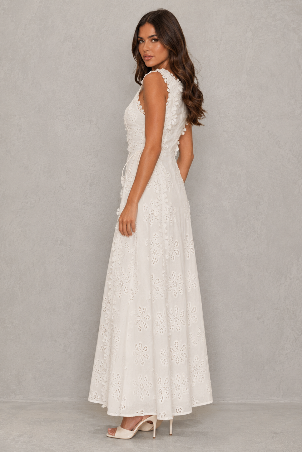 Womenโs embroidered cotton maxi dress with floral detailing, a fitted bodice, lace accents, lace-up detail, and a flowing full-length skirt.