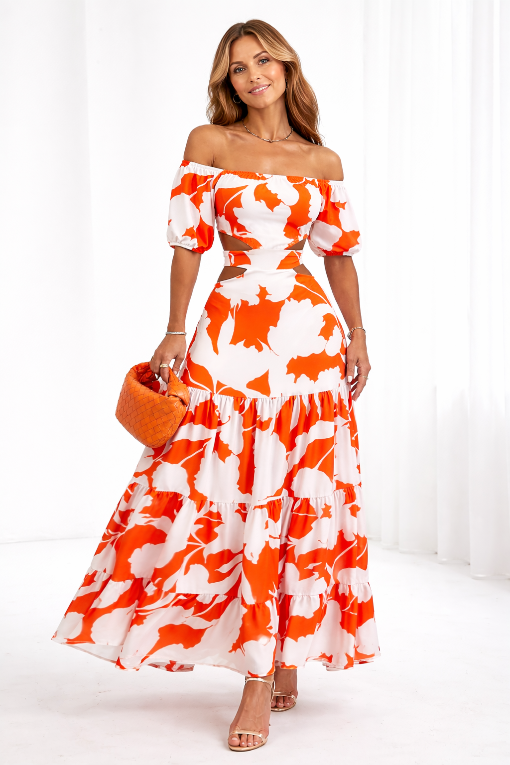 Woman wearing a red and white floral off-shoulder dress on a white background