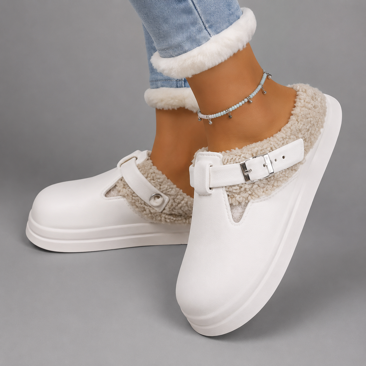 Women’s fur-lined mule slippers with a waterproof upper, plush faux fur lining, metal buckle accent, cushioned sole, and open-back slip-on design.
