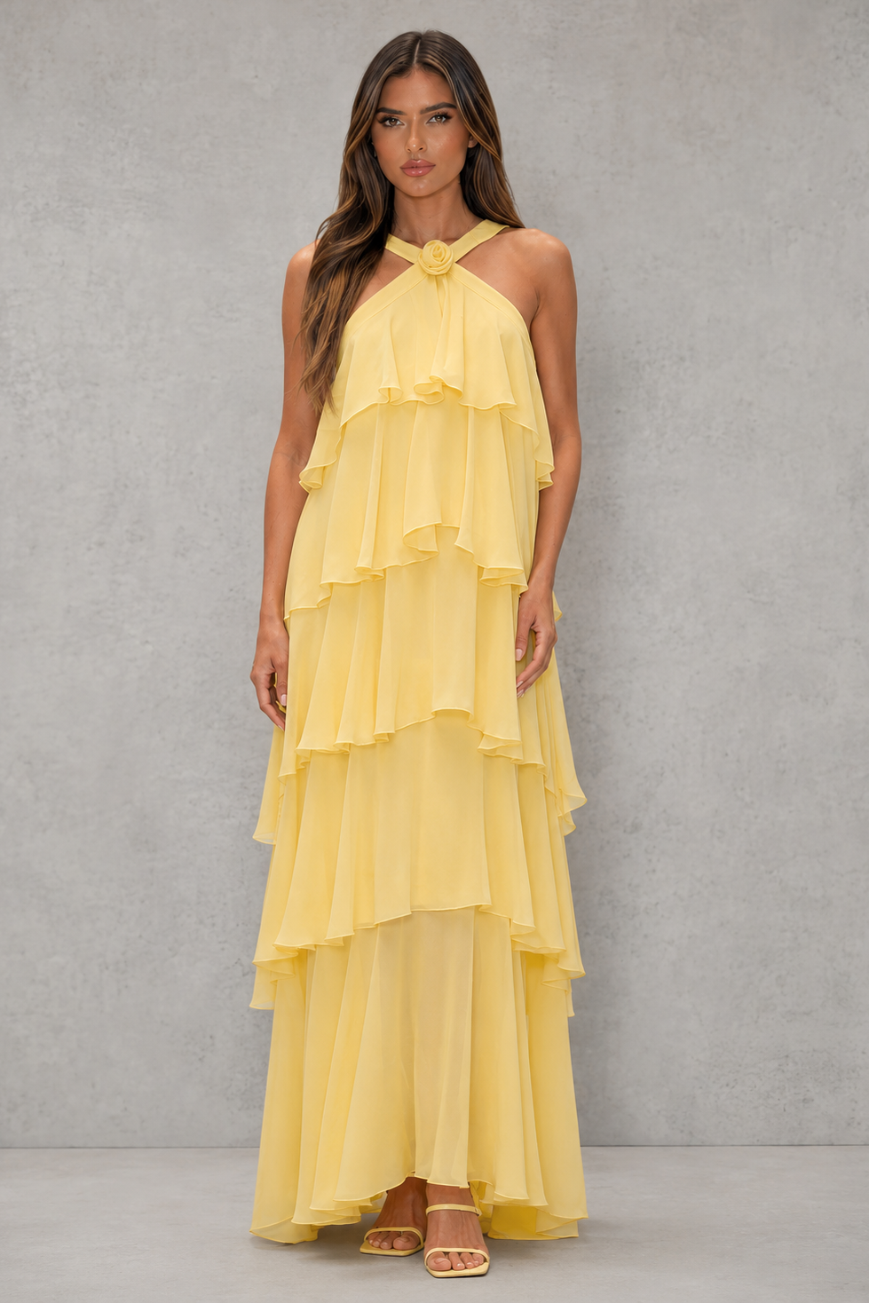 Womenโs butter yellow halter chiffon maxi dress with 3D floral rosette, asymmetrical tiered skirt and flowing silhouette for weddings and evening wear.