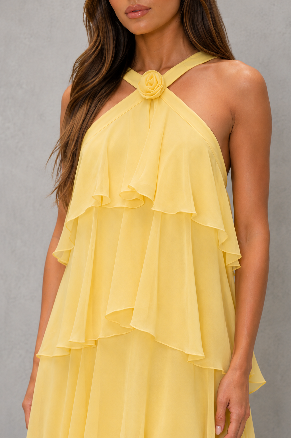 Womenโs butter yellow halter chiffon maxi dress with 3D floral rosette, asymmetrical tiered skirt and flowing silhouette for weddings and evening wear.