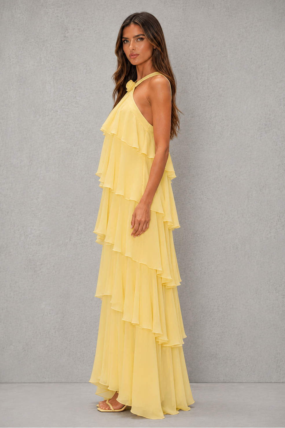 Womenโs butter yellow halter chiffon maxi dress with 3D floral rosette, asymmetrical tiered skirt and flowing silhouette for weddings and evening wear.