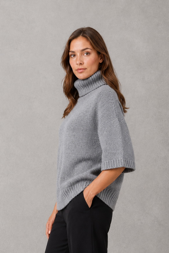 Women’s high neck batwing knit sweater with textured detailing, relaxed poncho-style silhouette, flowing sleeves, and a flattering waist-defining shape.