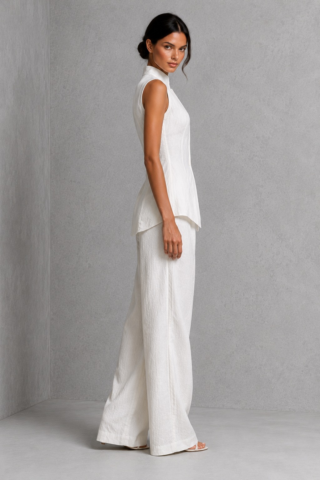 Women’s two-piece set featuring a sleeveless high-neck button-front top with a layered hem and matching flowing wide-leg pants.