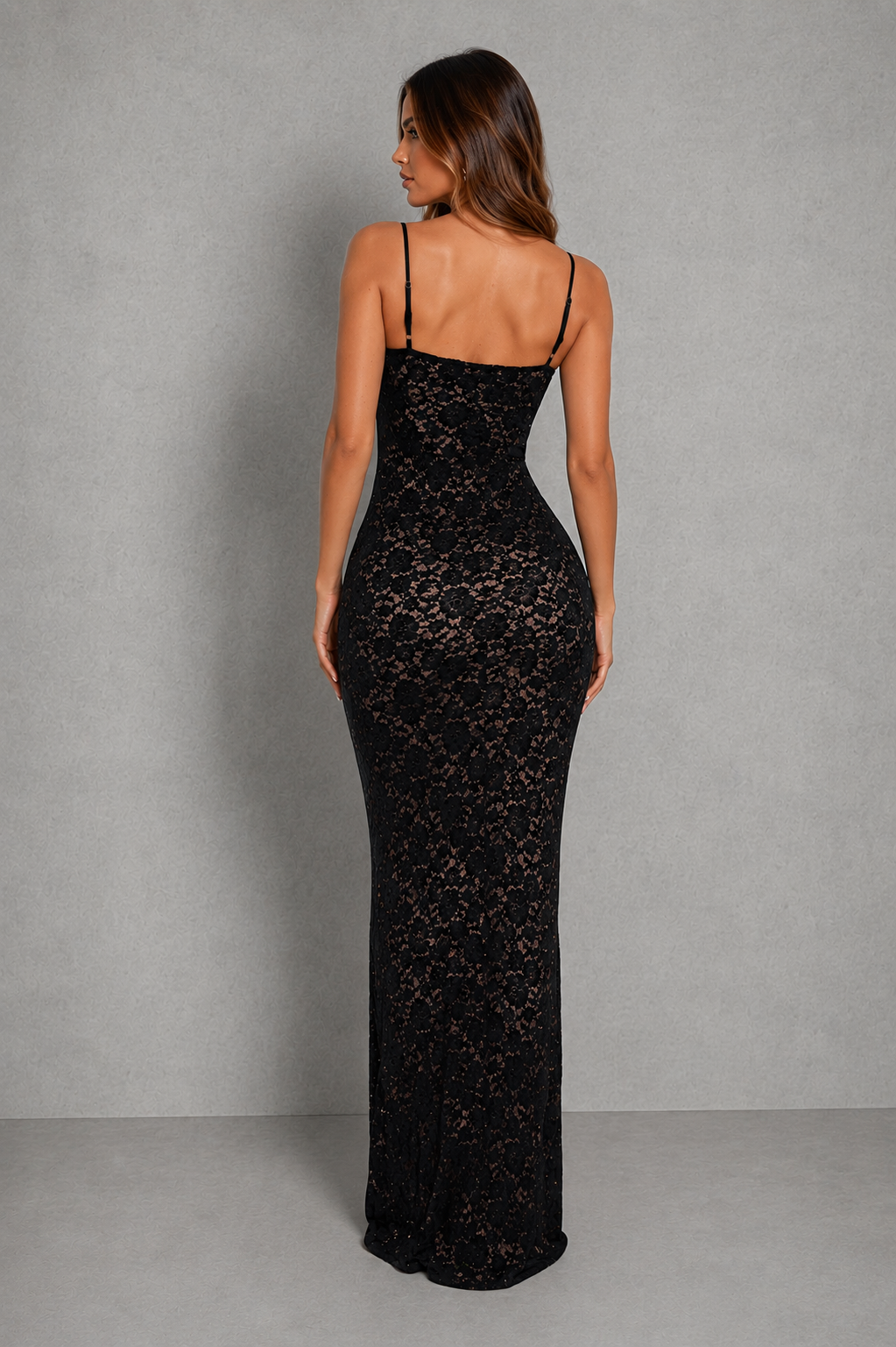 Woman wearing a black lace maxi dress with a sweetheart neckline, adjustable shoulder straps, figure-hugging silhouette, and softly flared hem, styled for evening events and special occasions.