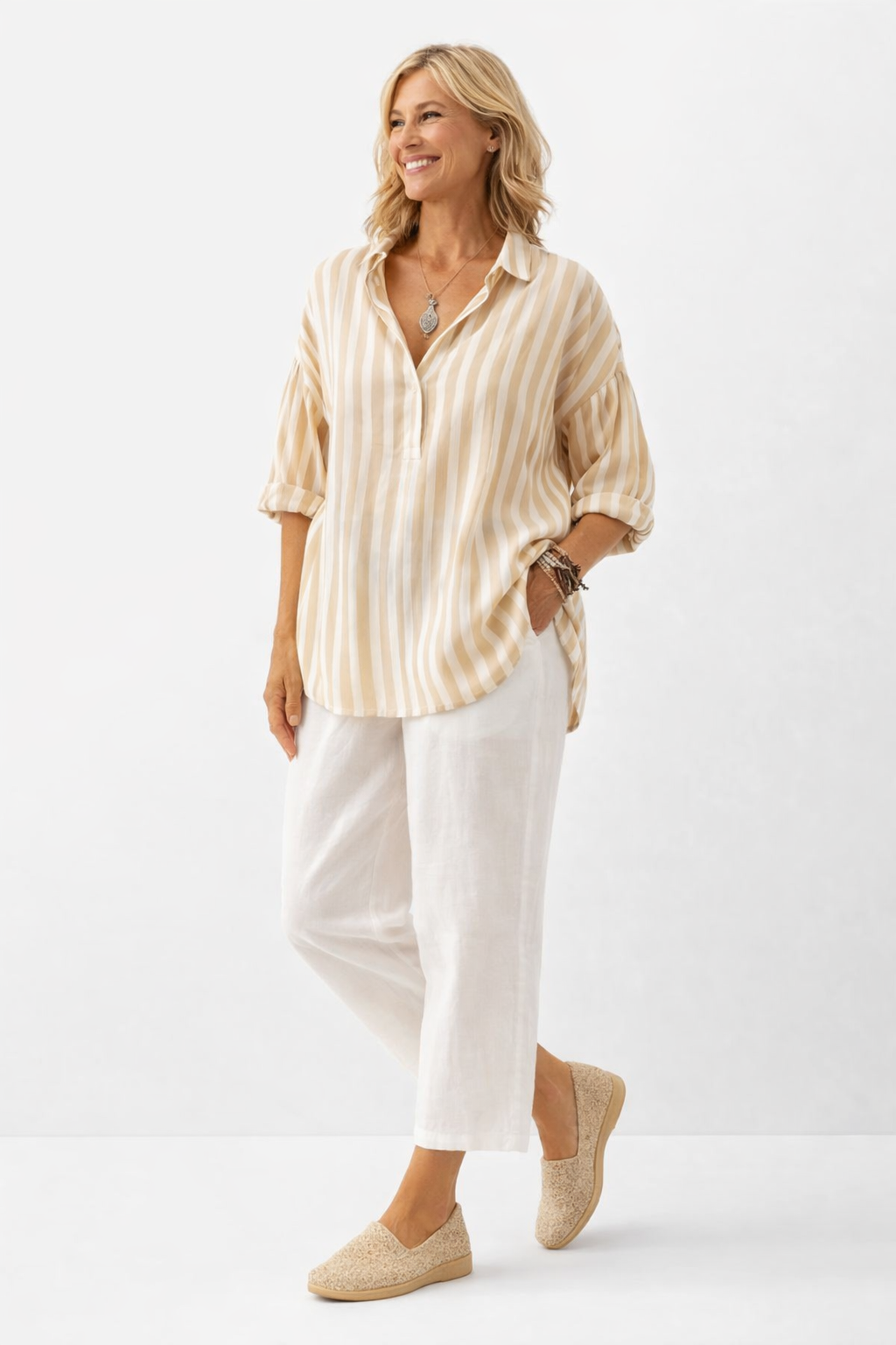 Woman wearing a striped shirt and white pants on a white background