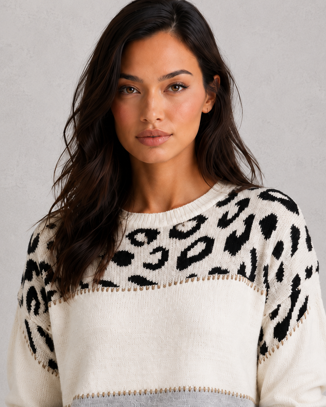 Woman wearing a mixed-pattern knit jumper with a relaxed fit and long sleeves, styled for a modern casual-chic look.