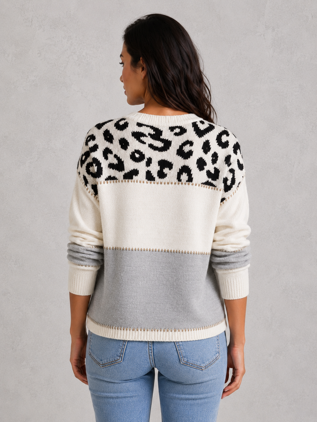 Woman wearing a mixed-pattern knit jumper with a relaxed fit and long sleeves, styled for a modern casual-chic look.