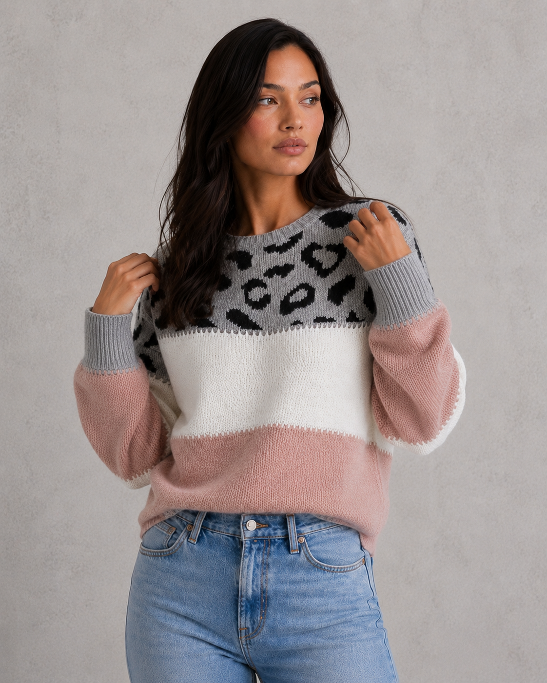 Woman wearing a mixed-pattern knit jumper with a relaxed fit and long sleeves, styled for a modern casual-chic look.