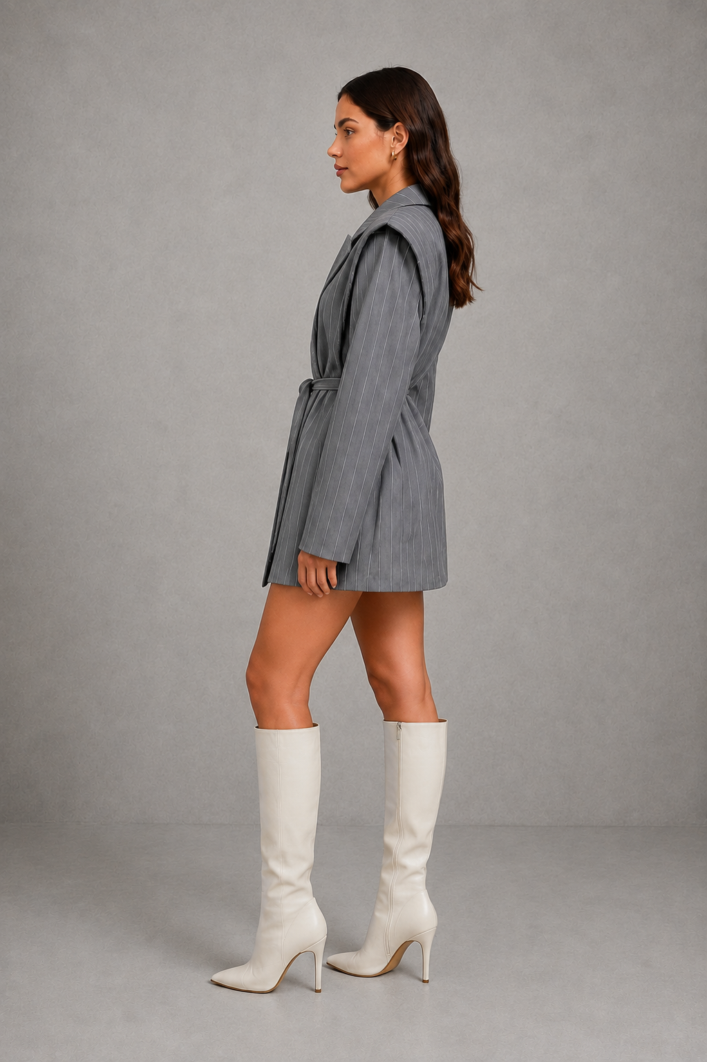 Women’s pinstripe belted longline blazer with structured shoulders, classic lapels, fine vertical stripes, long sleeves, and an adjustable self-tie waist.