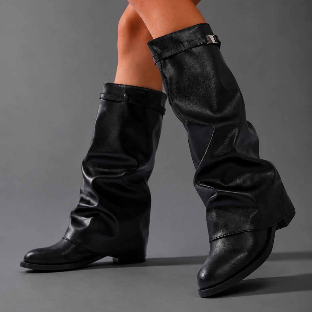 Women’s pointed toe slouch knee-high boots with a relaxed shaft, low block heel, pull-on design, and polished metal cuff detail.