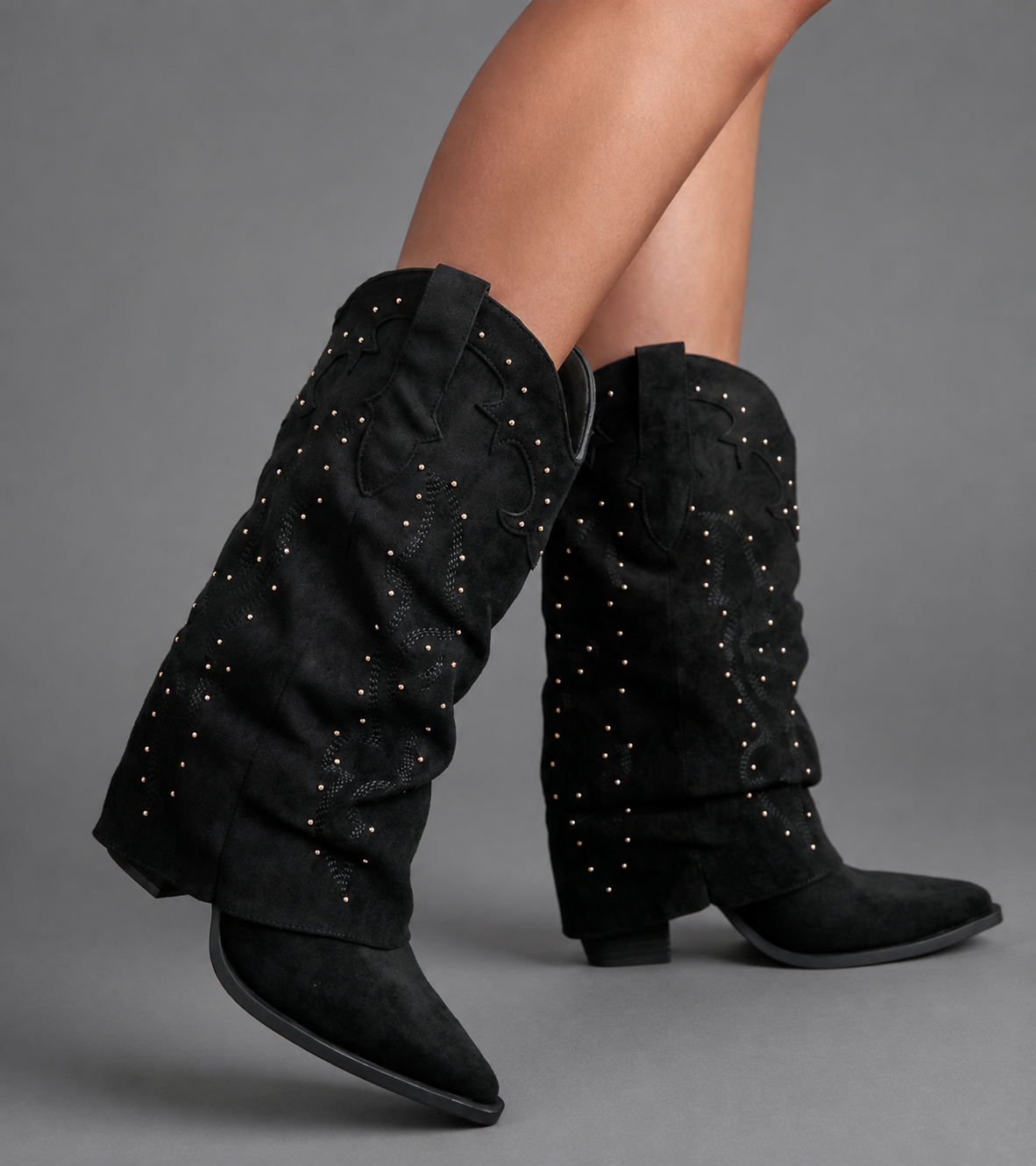 Women’s pointed toe Western knee-high boots with a relaxed slouchy shaft, low chunky heel, decorative pull tabs, and cowboy-inspired silhouette.