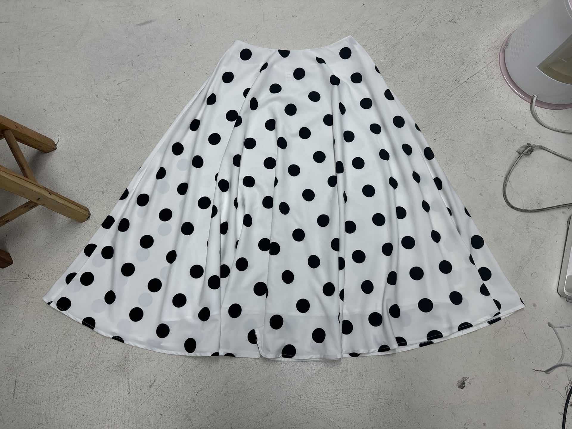 Womenโs flowy maxi skirt featuring a classic black-and-white polka dot pattern, lightweight breathable fabric, and a relaxed silhouette for comfortable everyday wear.