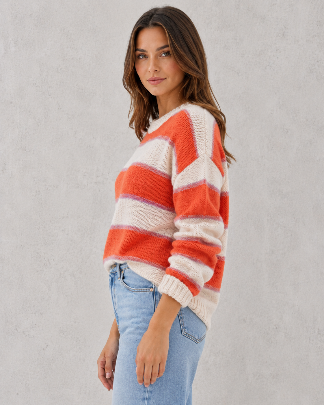 Woman wearing a regular fit blush and cream striped acrylic jumper with a soft knit texture and relaxed everyday styling.