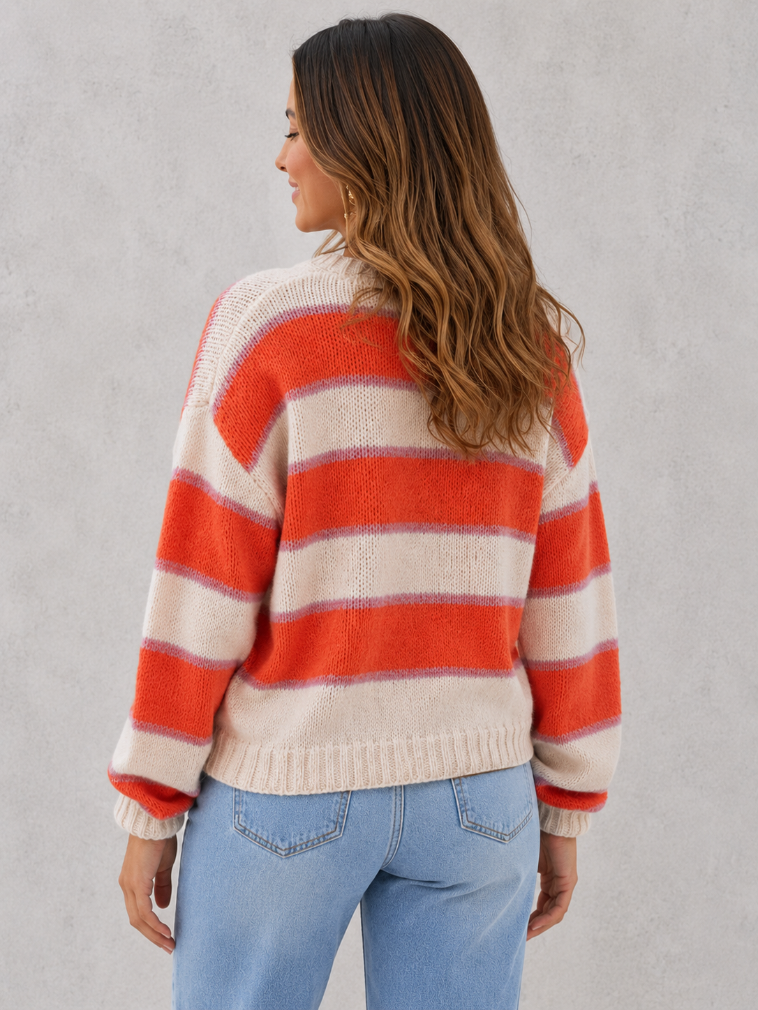 Woman wearing a regular fit blush and cream striped acrylic jumper with a soft knit texture and relaxed everyday styling.