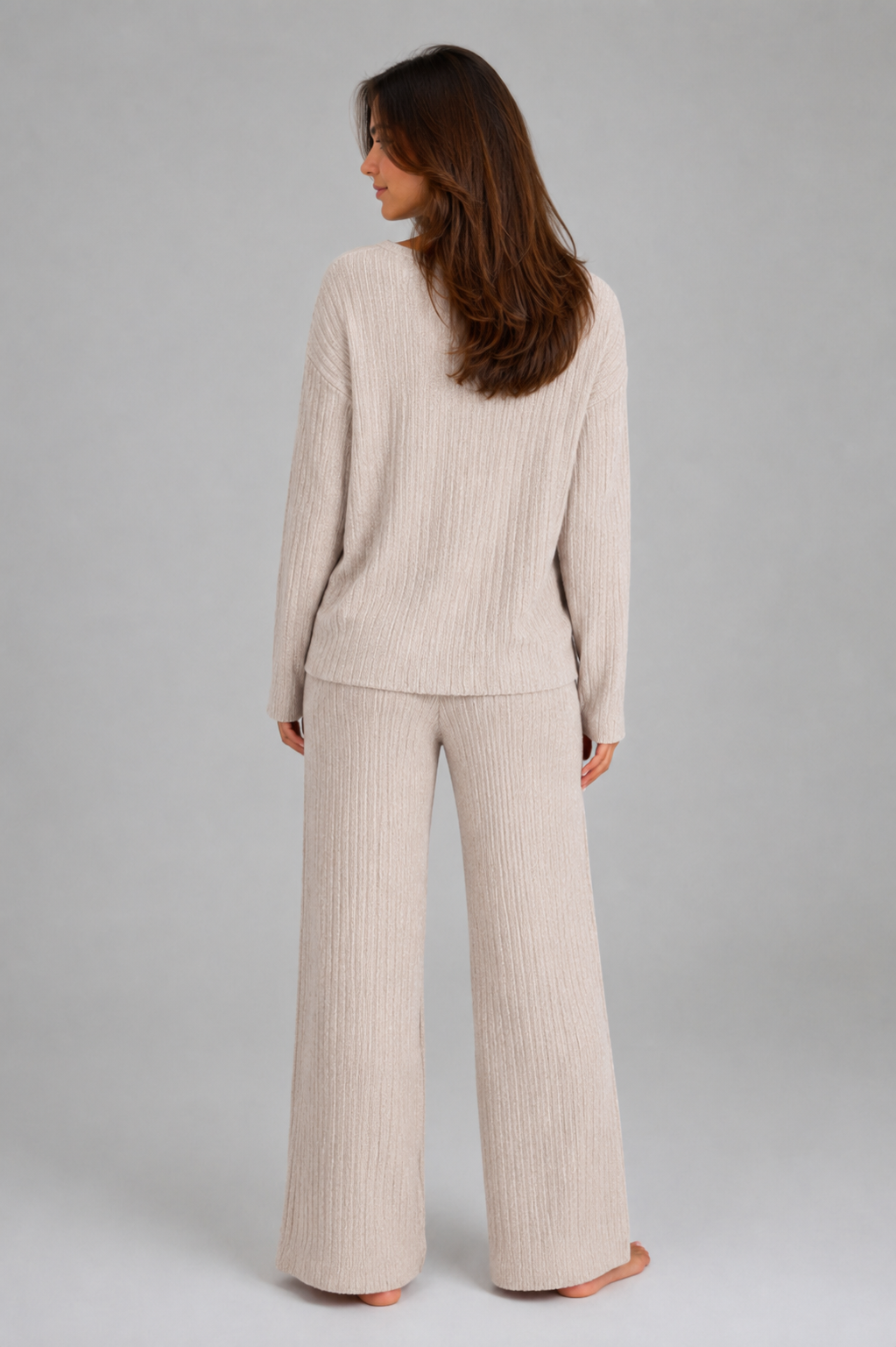 Women’s ribbed knit two-piece lounge set featuring a relaxed V-neck sweater and matching wide-leg pants with a soft, textured finish.