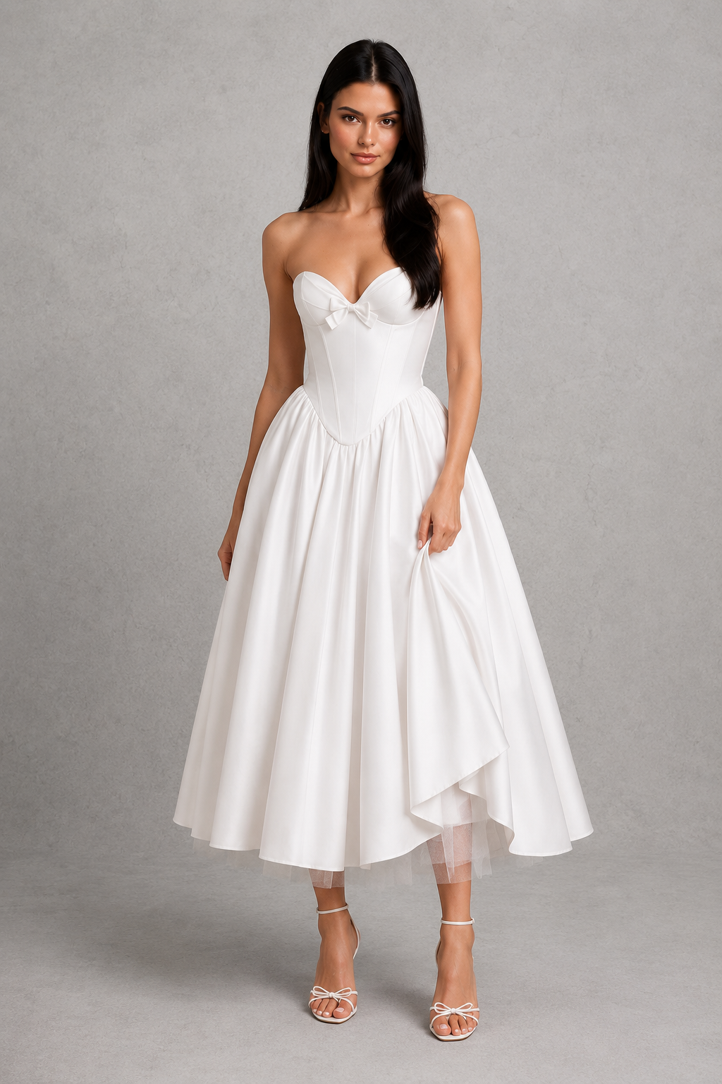 Women's strapless corset midi dress with a sweetheart neckline, pleated cups, bow detail, structured boned bodice, and a full tulle-lined gathered skirt, designed for elegant party and occasion wear.