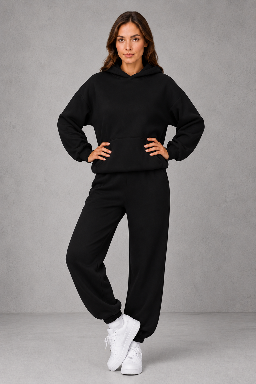 Women’s two-piece tracksuit set featuring a relaxed drawstring hoodie with front pocket and matching tapered jogger pants with cuffed ankles.