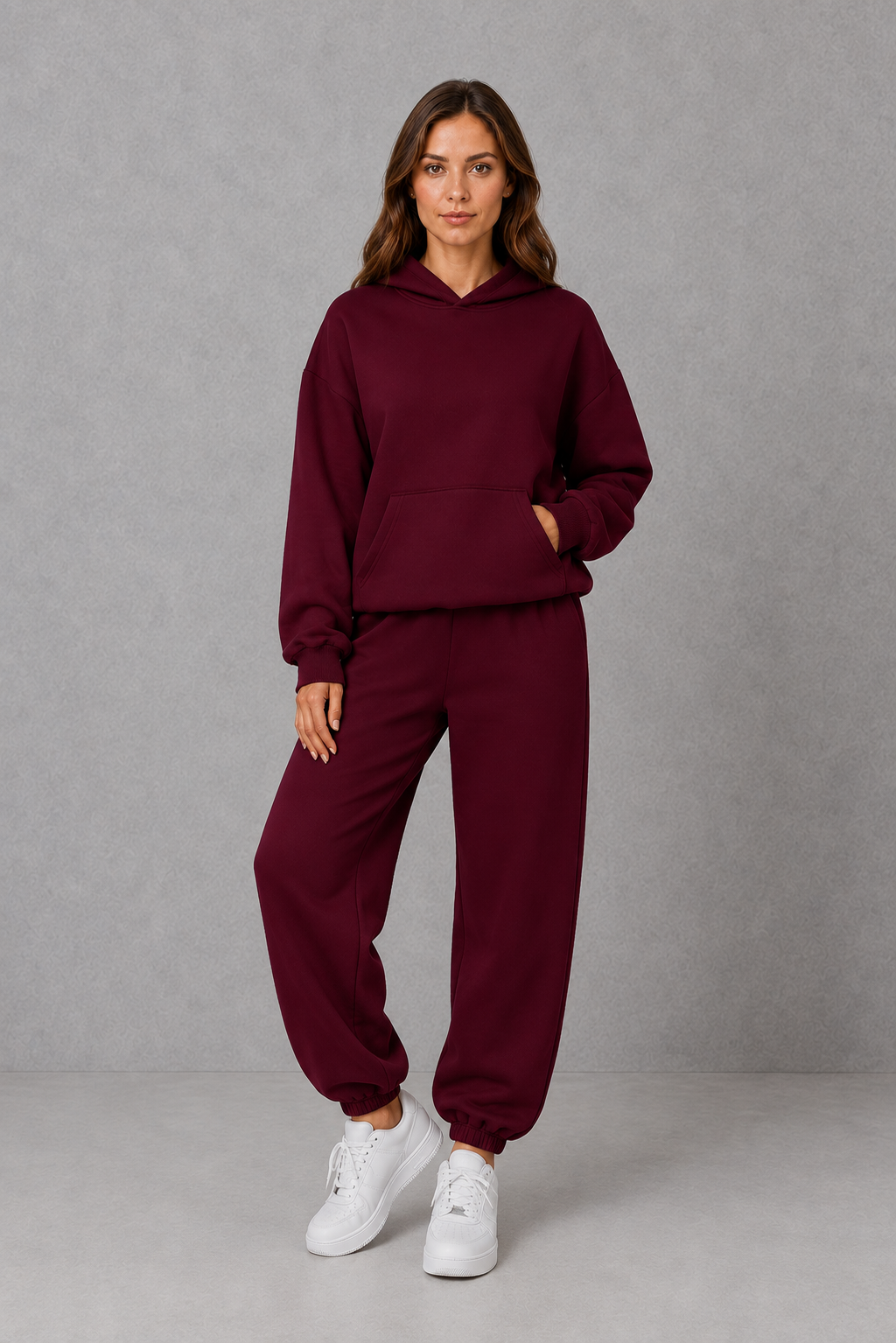 Women’s two-piece tracksuit set featuring a relaxed drawstring hoodie with front pocket and matching tapered jogger pants with cuffed ankles.