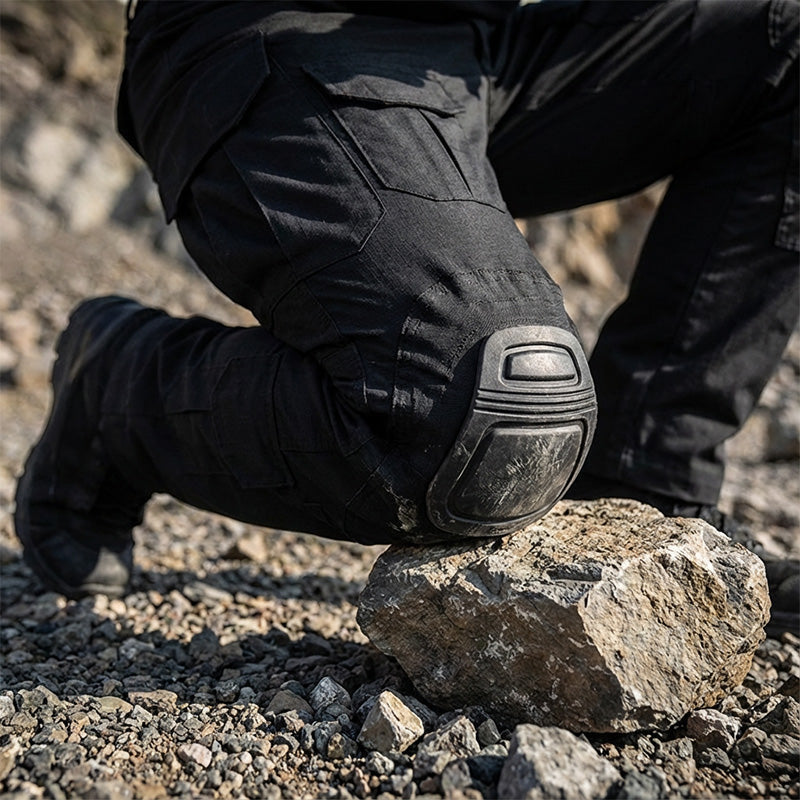 Men’s tactical cargo pants with integrated knee pads, adjustable straps, multiple pockets, and durable cotton-polyester fabric for outdoor work and rugged activities.