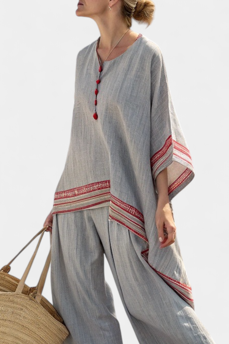 Women’s two-piece outfit featuring an asymmetrical blouse with embroidery and relaxed wide-leg pants designed for lightweight summer wear.