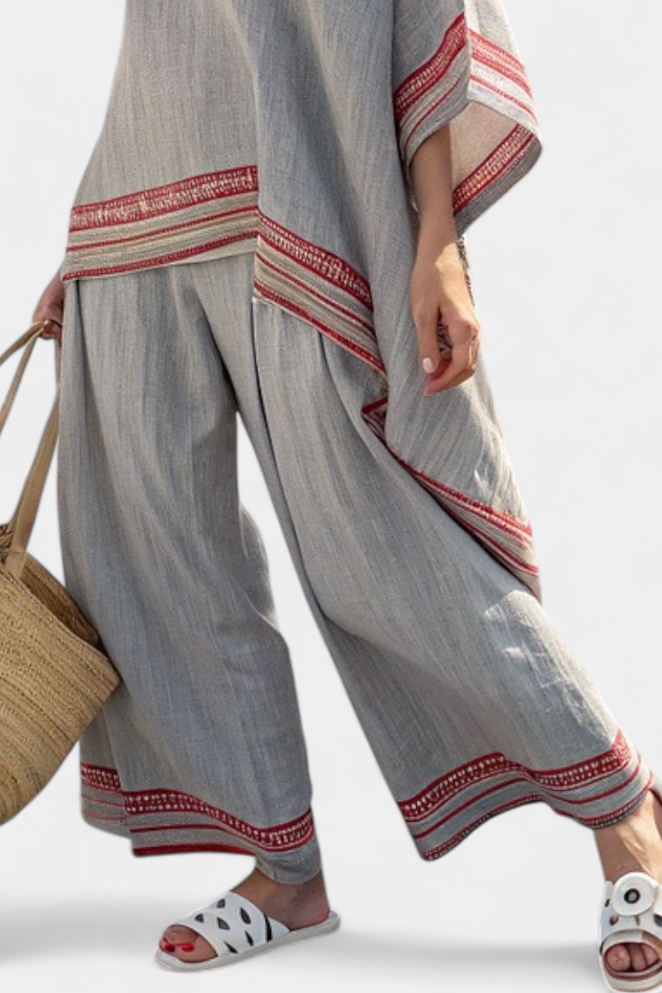 Women’s two-piece outfit featuring an asymmetrical blouse with embroidery and relaxed wide-leg pants designed for lightweight summer wear.