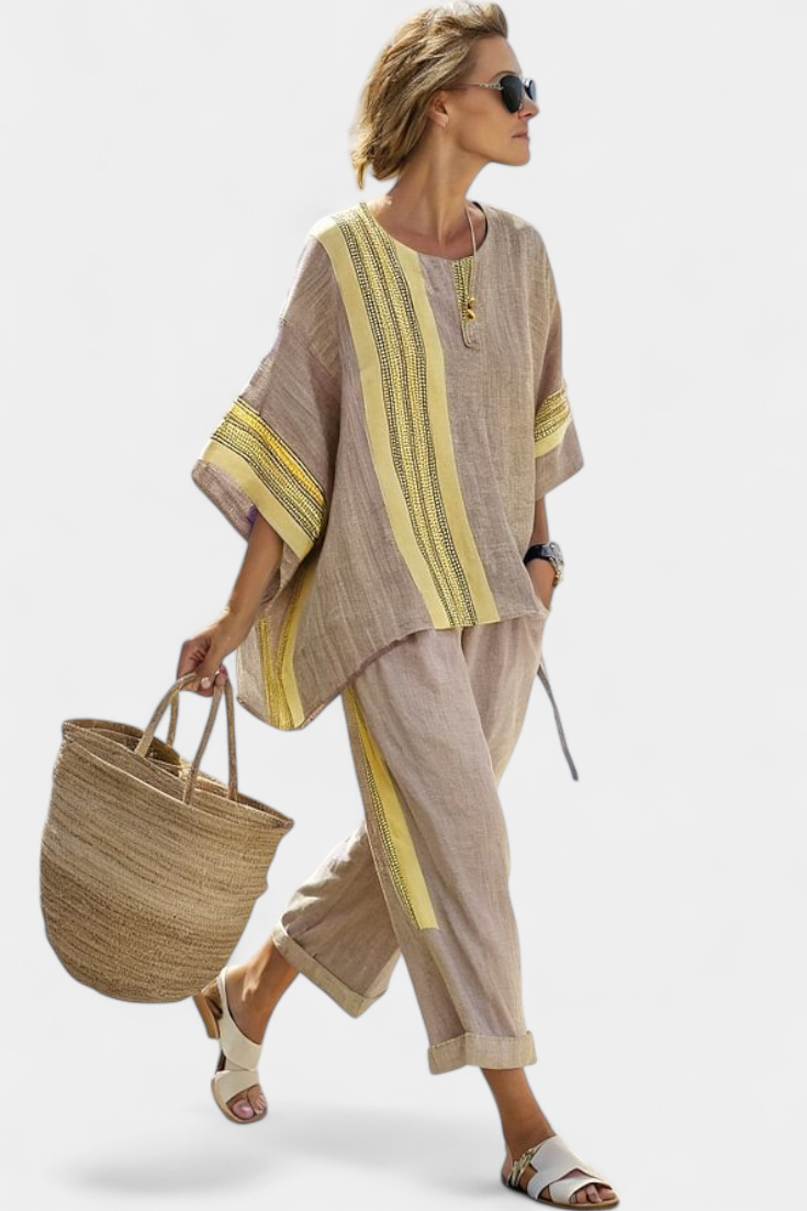 Women’s two-piece outfit featuring an asymmetrical blouse with embroidery and relaxed wide-leg pants designed for lightweight summer wear.