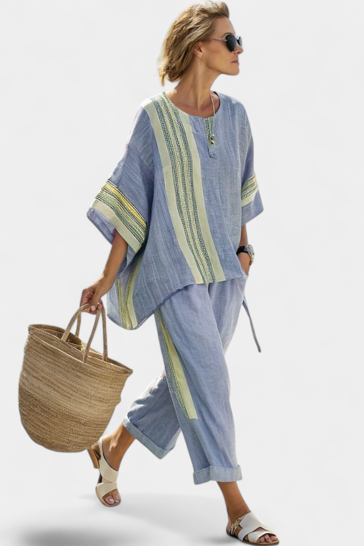 Women’s two-piece outfit featuring an asymmetrical blouse with embroidery and relaxed wide-leg pants designed for lightweight summer wear.