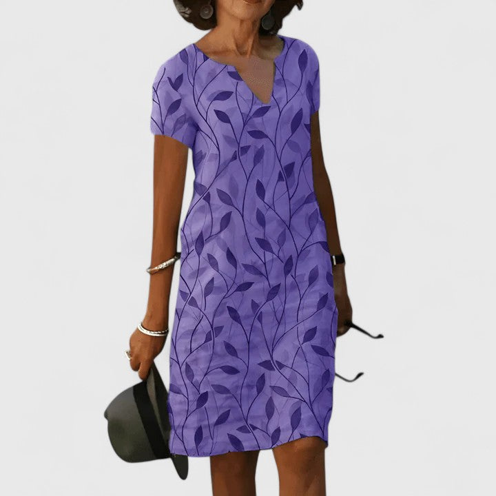 Women’s breathable cotton summer dress with notched V-neckline, soft leaf print, and relaxed waist fit for effortless style and comfort.