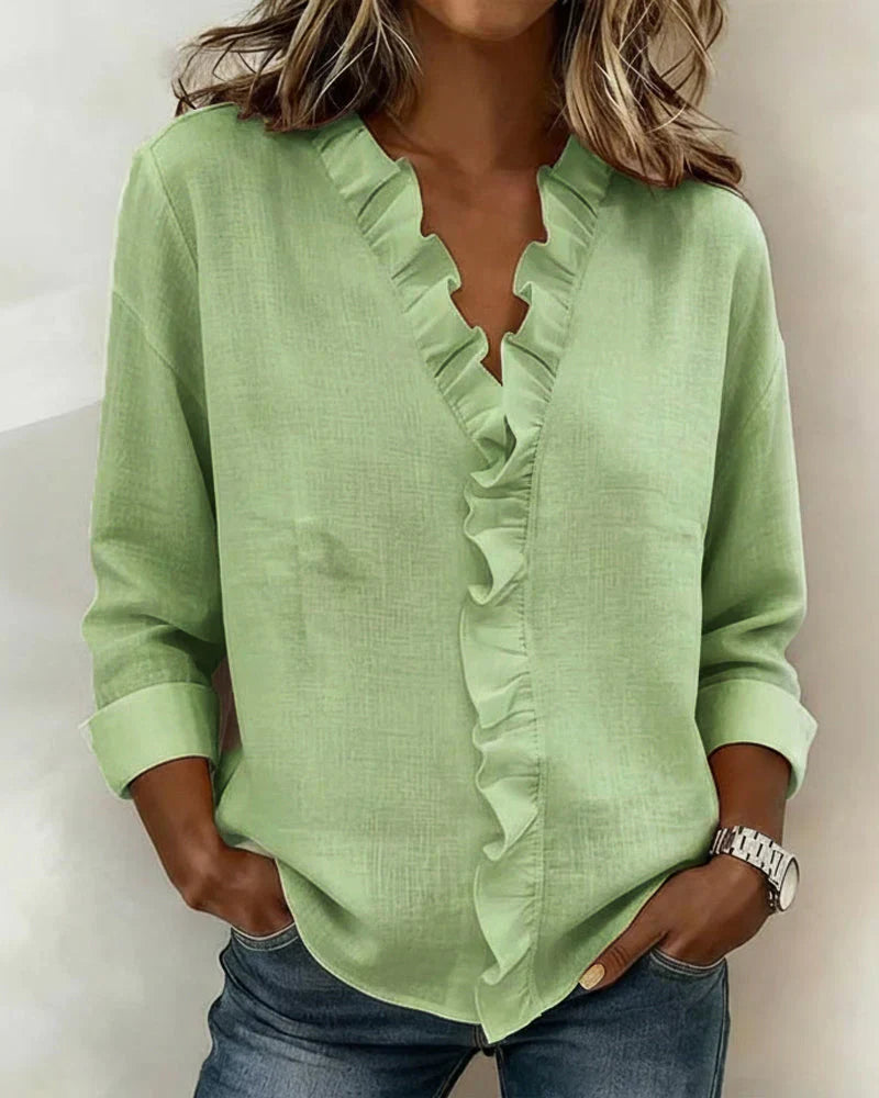 Women’s lightweight blouse with ruffled V-neckline, long sleeves, and clear cuffs, providing a relaxed, flattering silhouette for everyday wear.