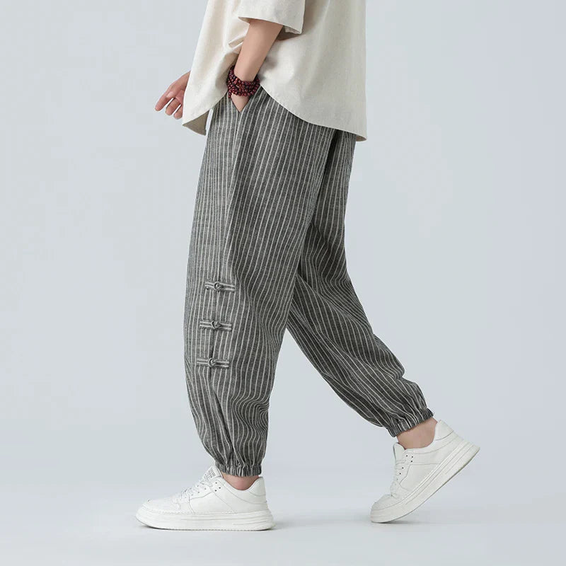 Menโs striped linen tapered trousers with elastic drawstring waistband and cuffed ankles for casual summer wear