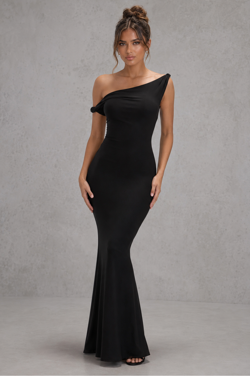 Woman wearing a women’s asymmetric bodycon maxi dress in premium double-layered stretch jersey with a twisted one-shoulder neckline, sleeveless fitted silhouette, and floor-length design for evening and formal occasions.