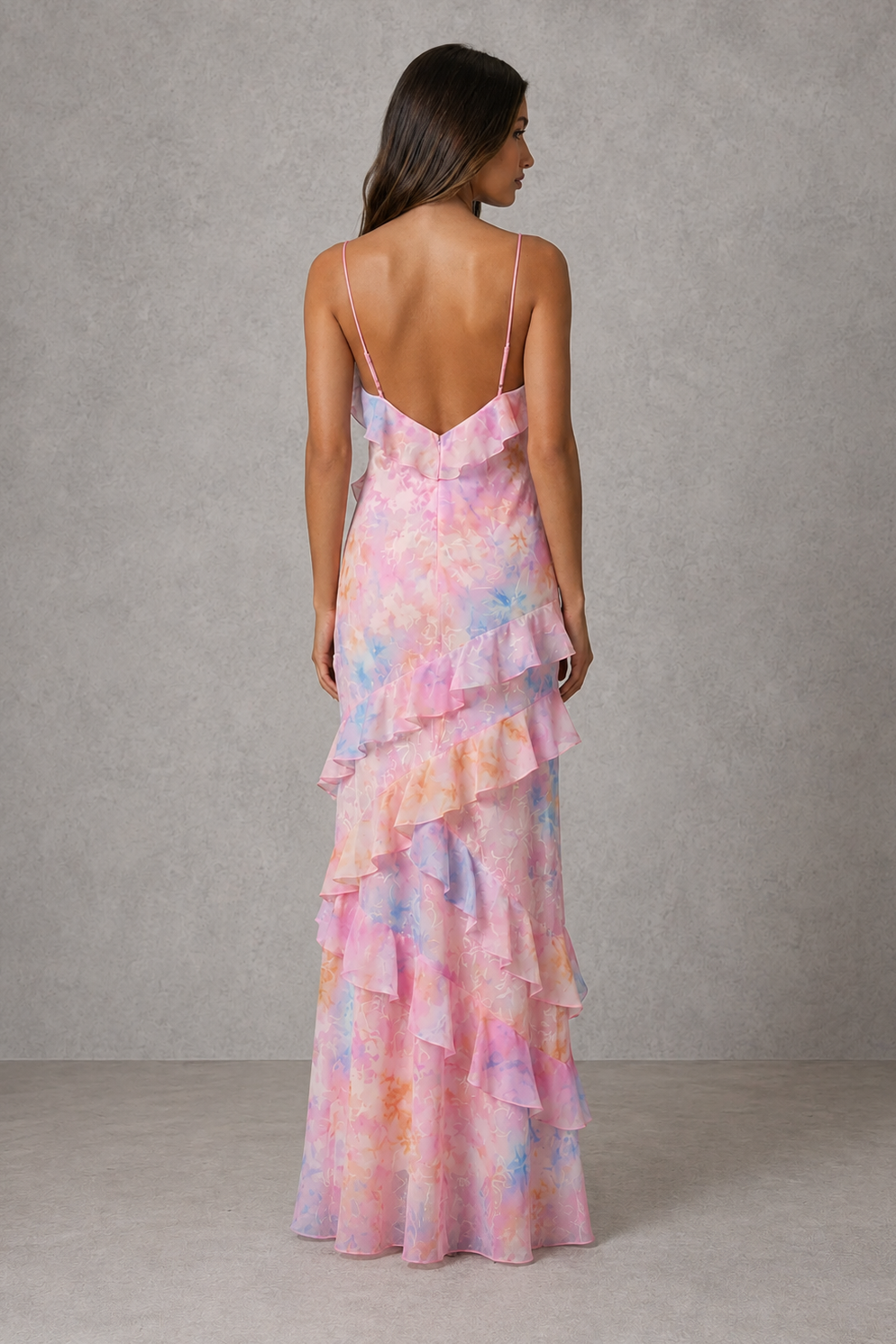 Womenโs floral chiffon maxi dress with V-neckline, adjustable shoulder straps, soft pastel print and cascading ruffle detail for wedding guest wear.