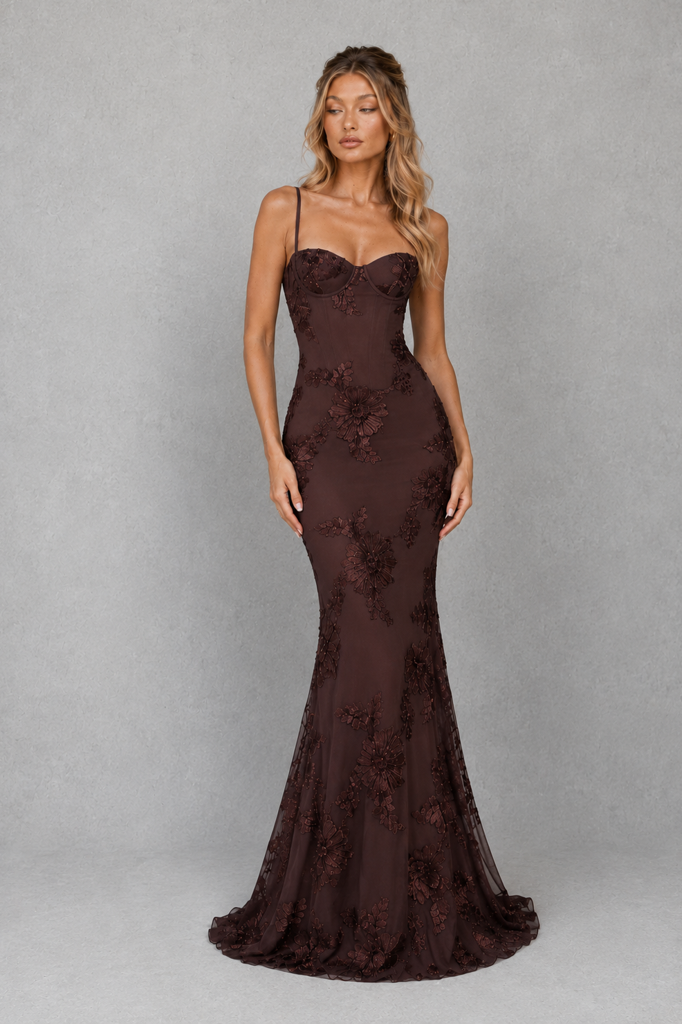 Woman wearing a women's floral embroidered corset maxi dress with a fitted bodice, delicate shoulder straps, defined waist, and flowing full-length skirt, designed for weddings, formal events, and special occasions.