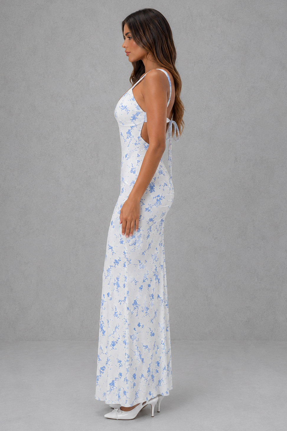 Womenโs blue floral mesh maxi dress with plunge neckline, adjustable straps, and feminine tie-back detail.
