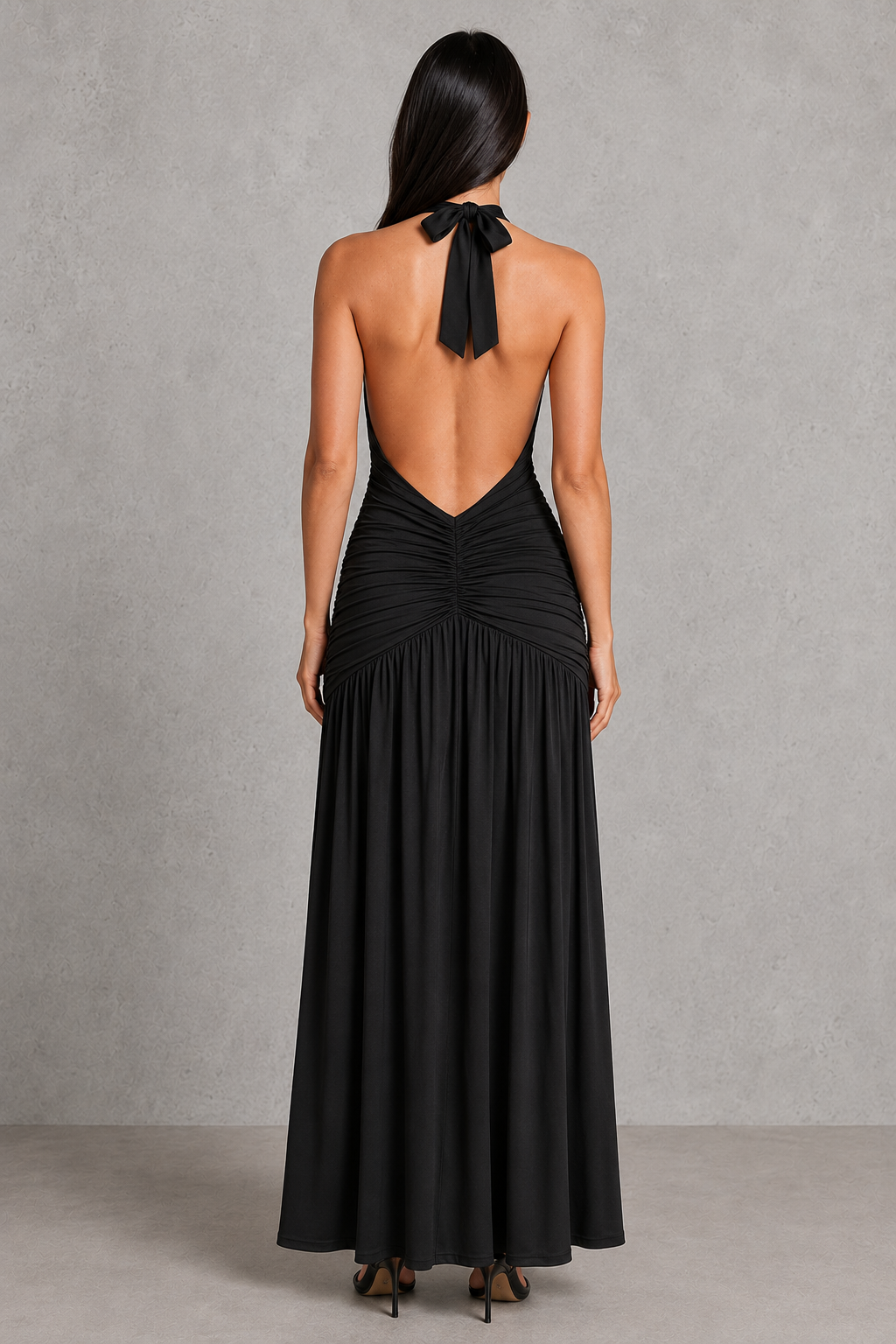Woman wearing a halter neck maxi dress with a plunging neckline, ruched hip detailing, low V-back, and thigh-high split. The figure-hugging silhouette flows into a graceful skirt, creating an elegant look for evening events, formal occasions, and special celebrations.