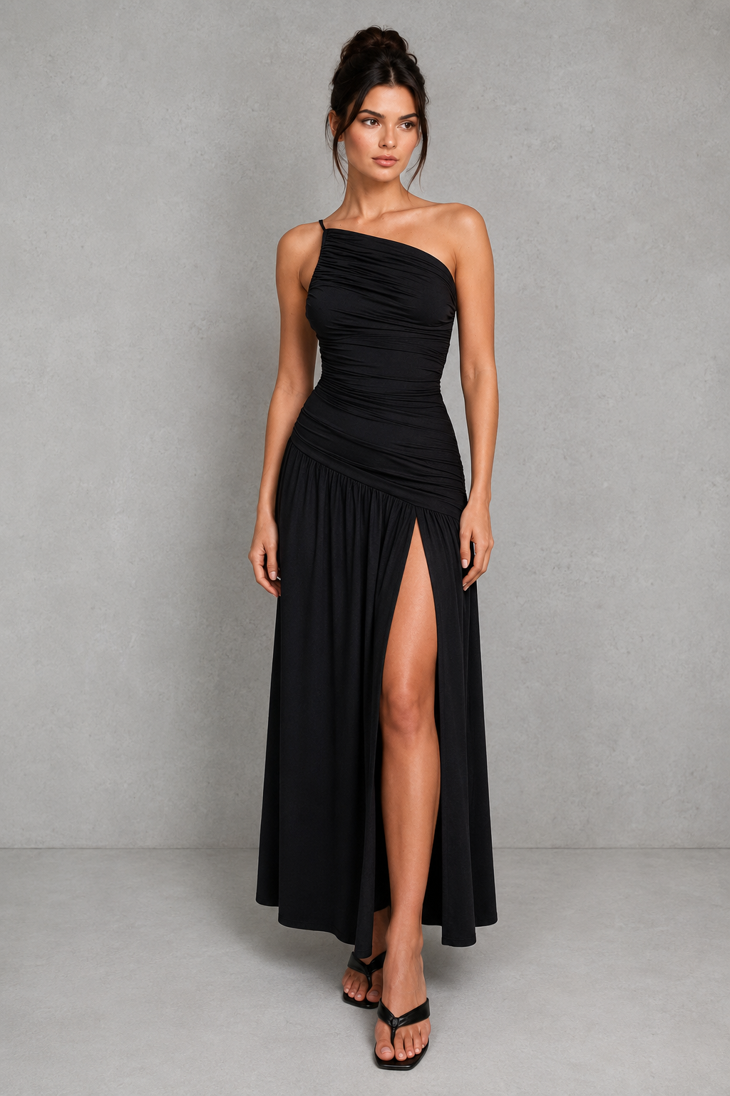 Woman wearing a one-shoulder maxi dress with gathered waist detailing, thigh-high split, and flowing skirt in premium slinky jersey for evening and formal occasions.