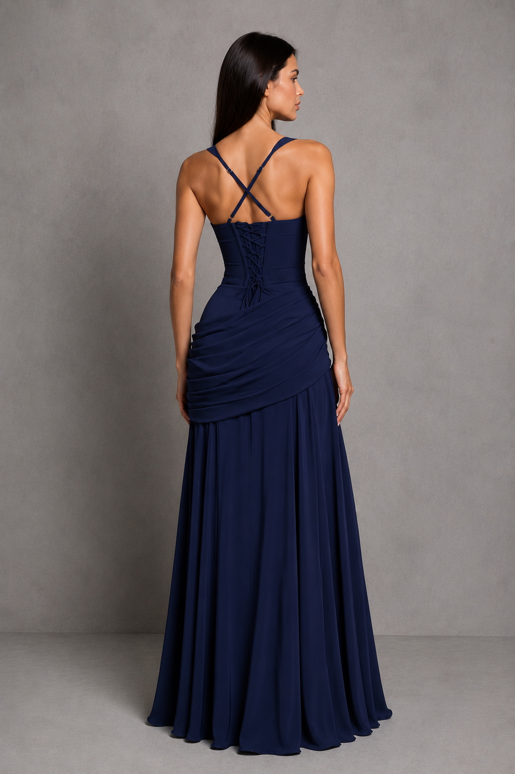 Womenโs chiffon maxi dress with a twist cowl neckline, crossover straps, asymmetric pleating, flowing godet skirt and lace-up back.